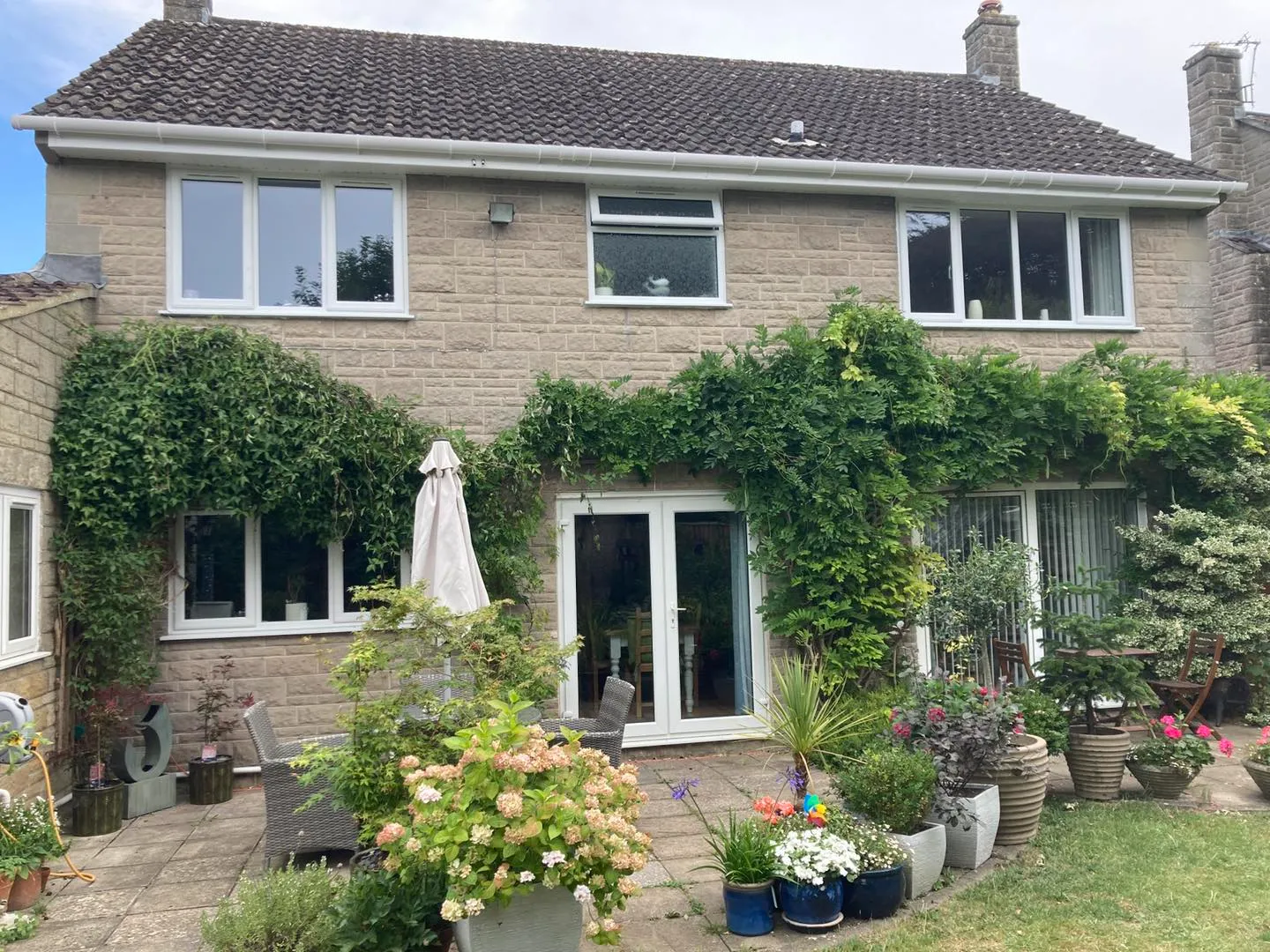 A house that has a bunch of plants in front of it.
